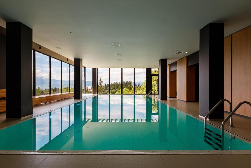 uma grande piscina com janelas de vidro num edifício em ШПИЦІ Hotel & SPA em Bukovel