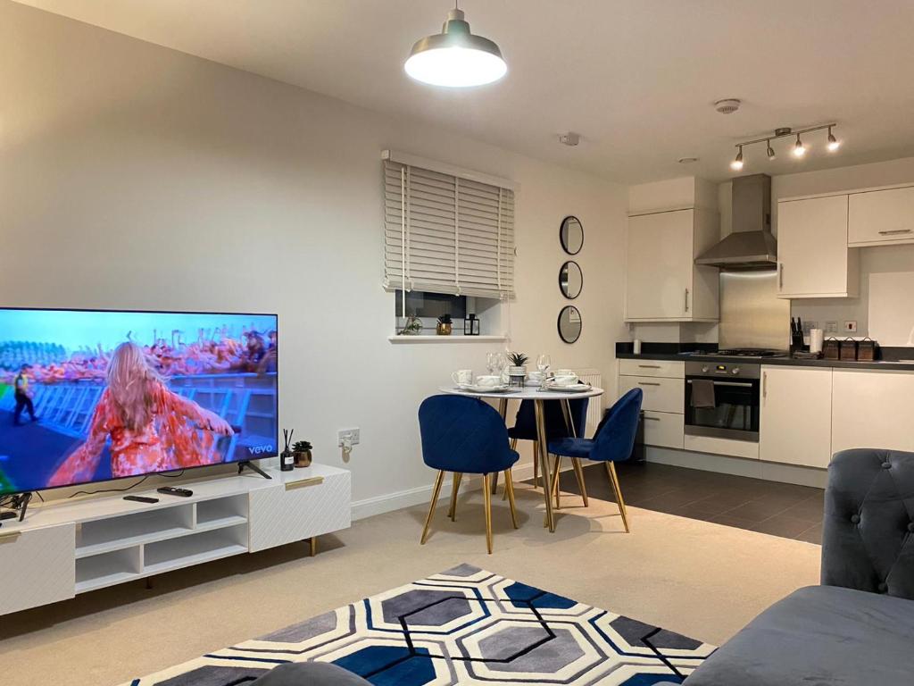 a living room with a large television and a kitchen at Stylish Station Apartment in Rochester with Free Parking in Wainscot