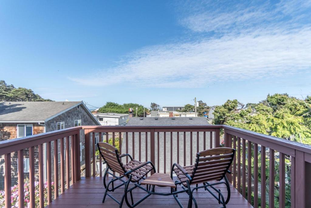 a patio with two chairs and a table on a deck at Family Tides in Lincoln City