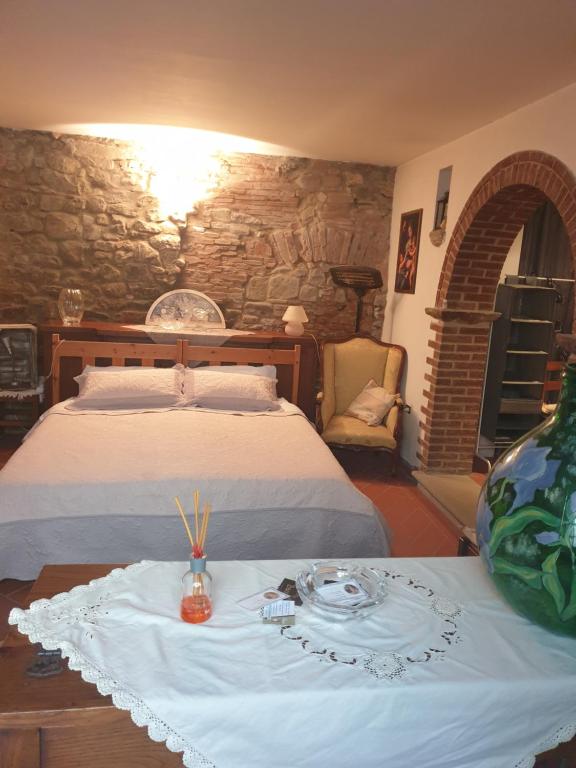 Un dormitorio con una cama y una mesa con un plato en Helga's House- Una Finestra sul Borgo, en Ambra