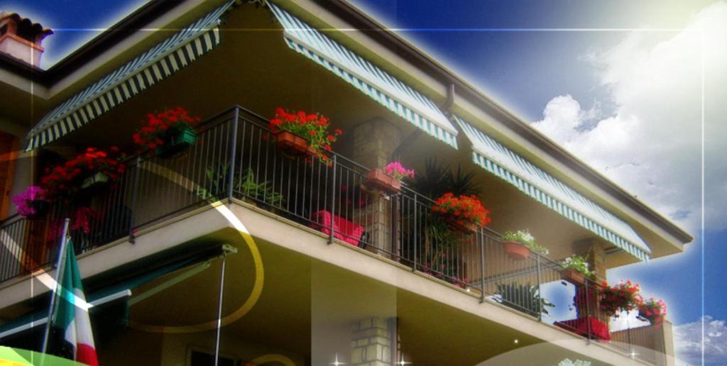 ein Gebäude mit Topfblumen auf dem Balkon in der Unterkunft Ladi’s B&B in Bardolino
