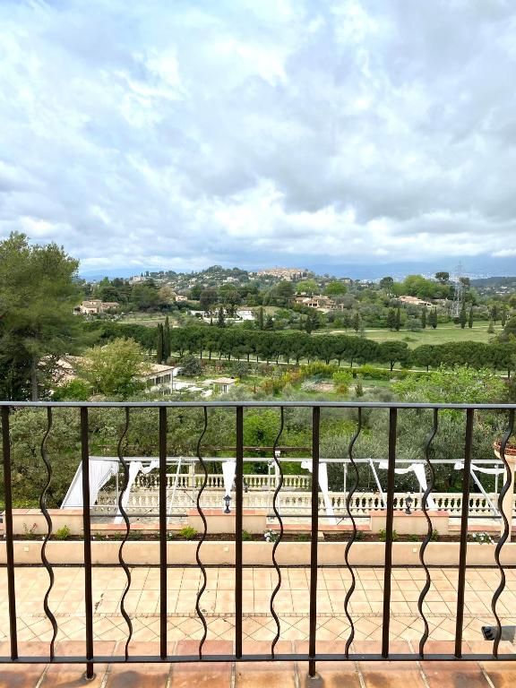 a balcony with chairs and a view of a park at Domaine du Paradis des Oiseaux in Mougins