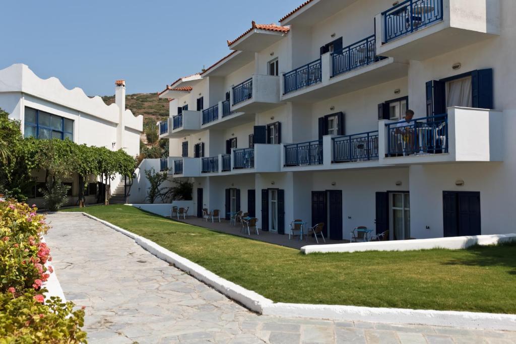 un grande edificio bianco con balconi blu di Saint Nicholas Hotel a Psilí Ámmos