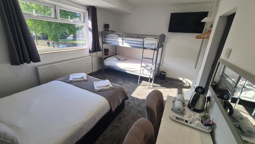 a room with a bed, a desk and a window at Y Gwynedd Inn in Llanberis