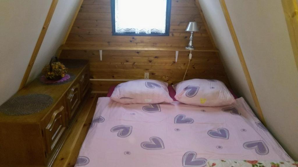 uma pequena casa com duas almofadas numa cama em Domek letniskowy 36 em Giżycko