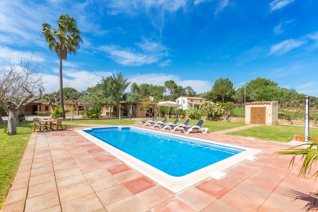 a swimming pool in a yard with chairs around it at Marilen - Finca with Large Garden & Pool in Alcudia