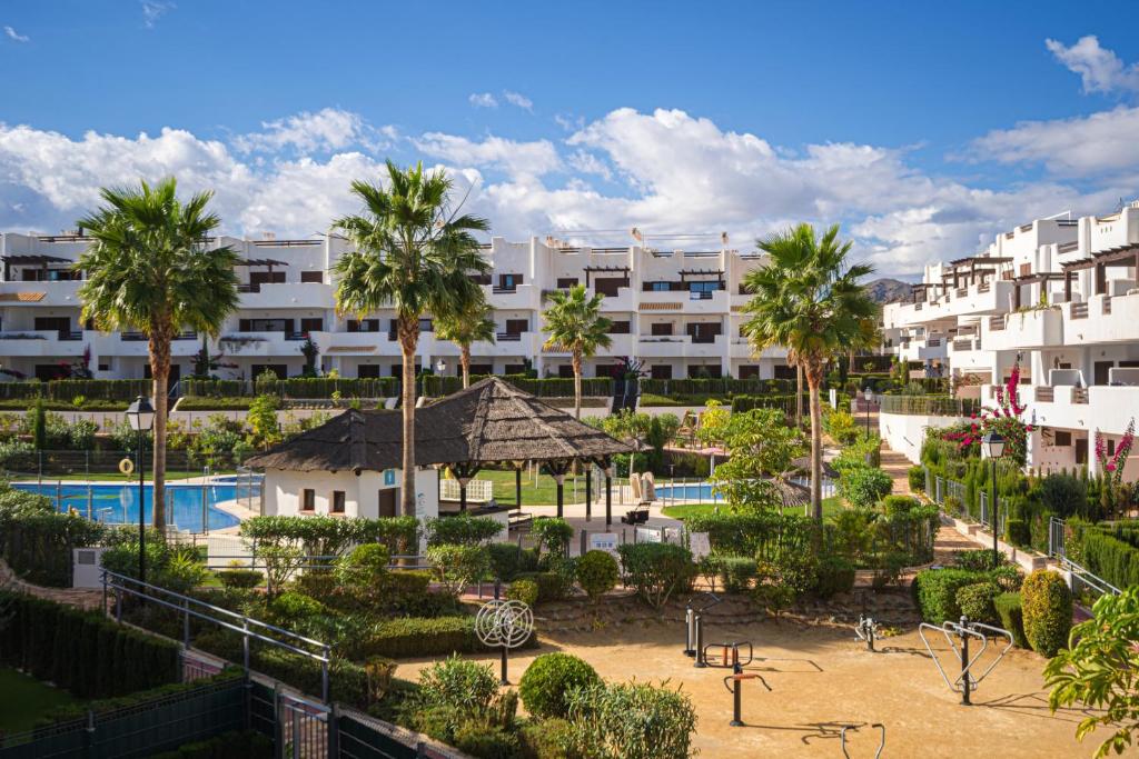 - une vue sur un complexe avec une piscine et des palmiers dans l'établissement Apartment Aguacate, à San Juan de los Terreros