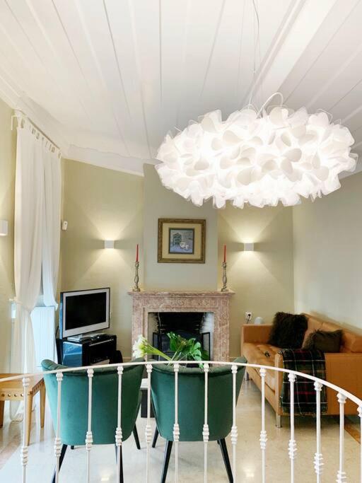 a living room with a fireplace and a chandelier at Lisbon Cottage Principe Real in Lisbon