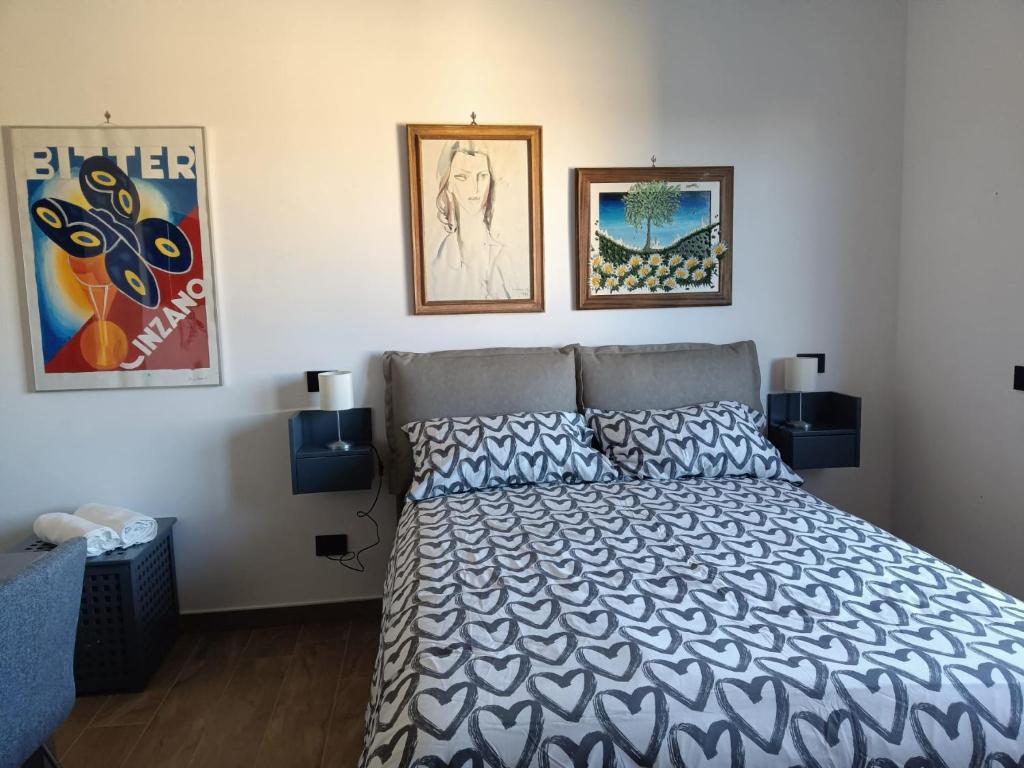 ein Schlafzimmer mit einem Bett und zwei Bildern an der Wand in der Unterkunft RICOMINCIO DA ME in Neapel
