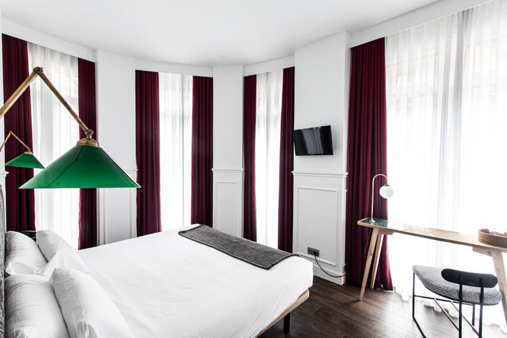 a bedroom with red and white striped walls at Hotel Trueba in San Sebastián