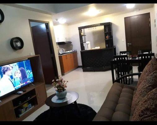 a living room with a couch and a tv at Cubao ManhattanHeights Unit 23D Tower C, 1 BR in Manila