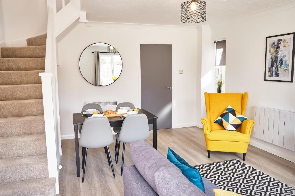 comedor y sala de estar con mesa y silla amarilla en Parkway House - Modern with great transport links en Bristol