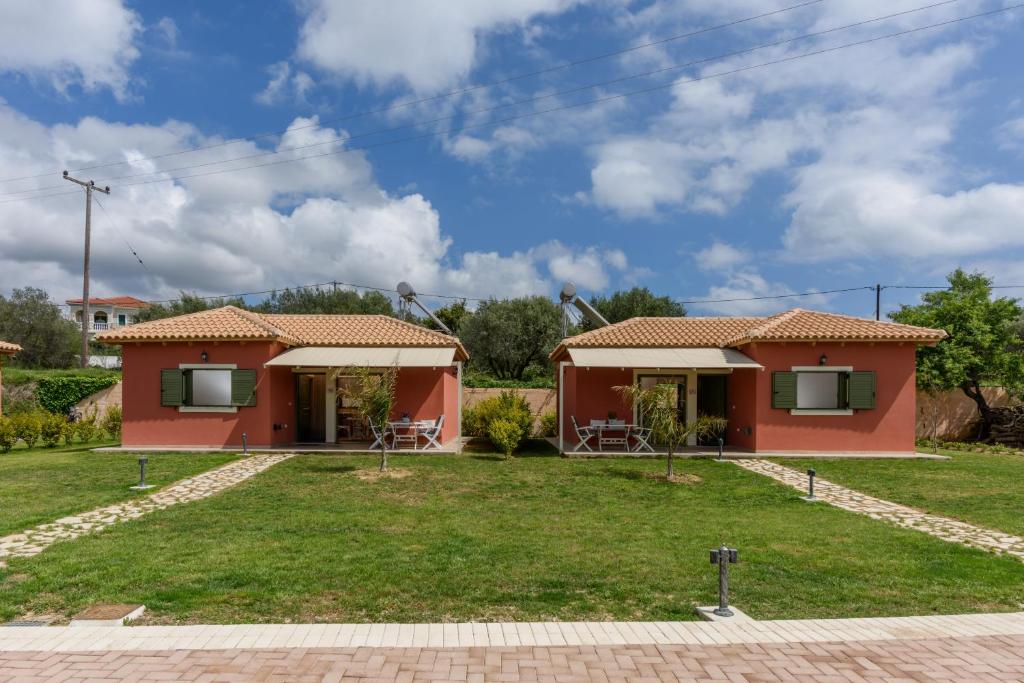eine Villa mit einem Garten und einem Haus in der Unterkunft Comfeto & Mandolato Sweet Houses in Lakíthra