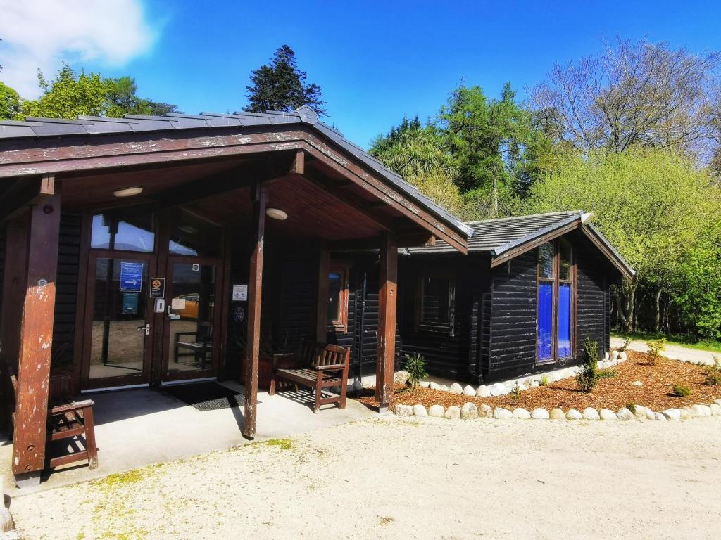 Cabaña de madera con porche y patio en Shore Lodge, en Brodick