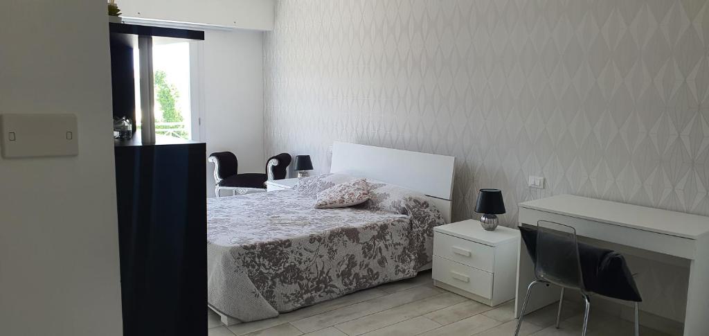 a bedroom with a bed and a desk and chairs at alhena room in Terracina