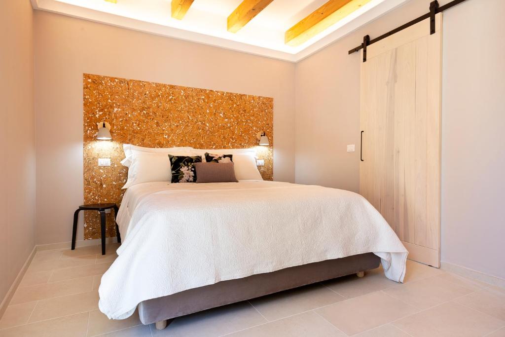 een slaapkamer met een groot bed met een groot hoofdeinde bij La VIA Rooms and Terrace in Olbia