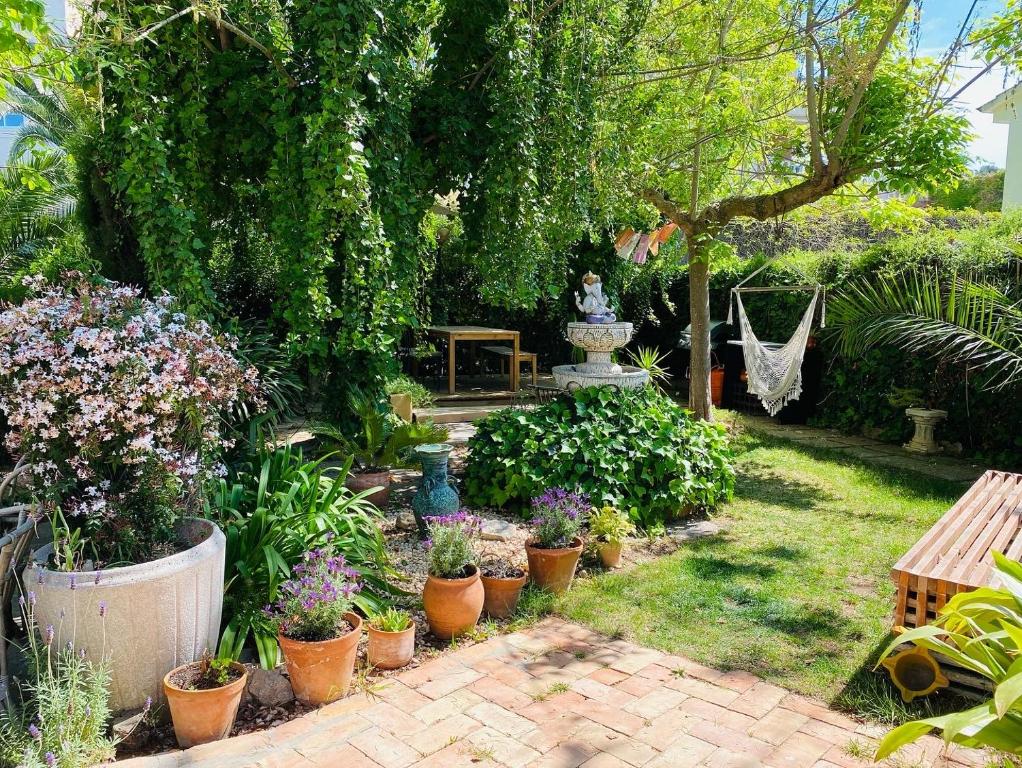 um jardim com muitos potes de flores e uma estátua em Charming apartment in a duplex with garden & balcony em Cunit