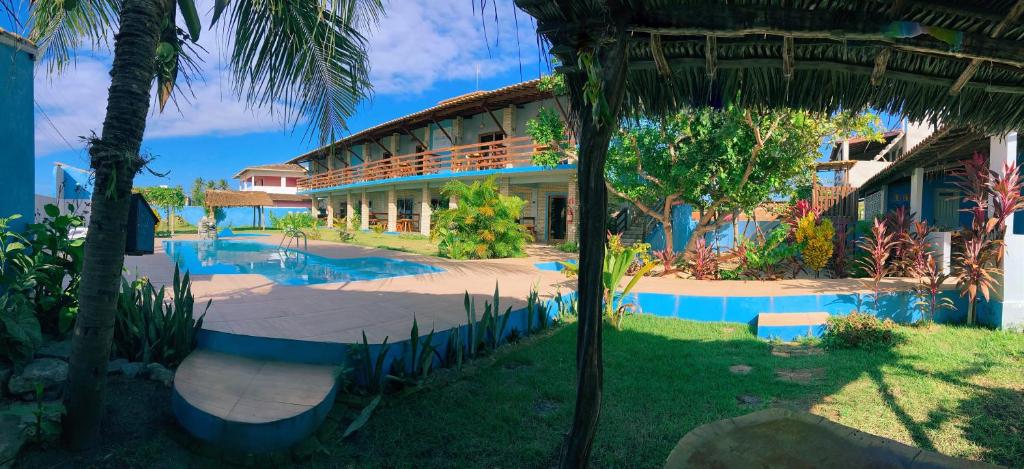 een resort met een zwembad en een gebouw bij Pousada Manga Azul in Barra de Camaratuba