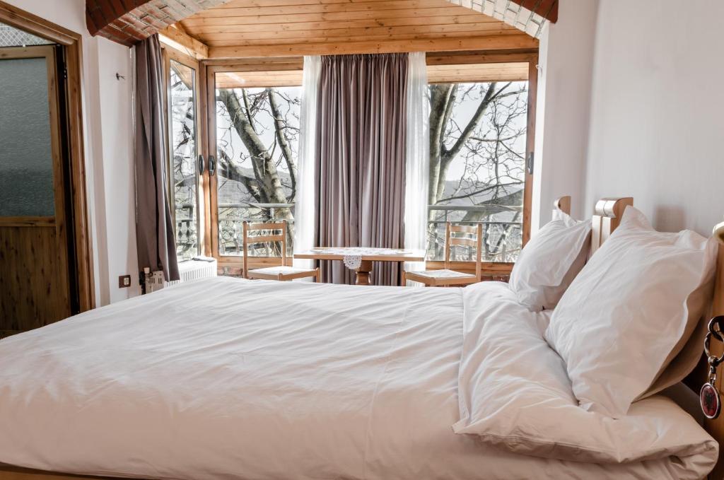 een groot wit bed in een kamer met een raam bij Alpeta Agrotourism & Winery - Roshnik , Berat in Roshnik