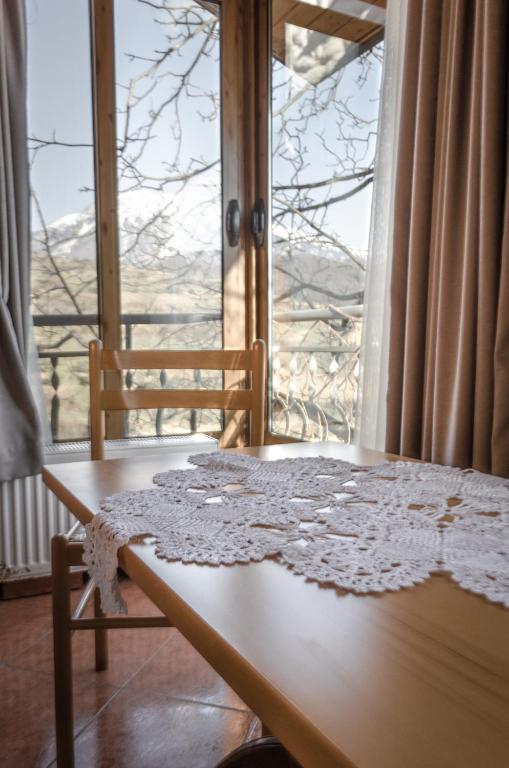 a room with a table and a window with a view at Alpeta Agrotourism & Winery - Roshnik , Berat in Berat