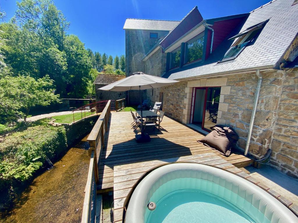 a backyard with a swimming pool and a house at Usine du Moulin du Pont Neuf in Trégrom