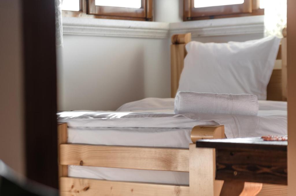 a bedroom with a bed with a wooden frame at Alpeta Agrotourism & Winery - Roshnik , Berat in Berat