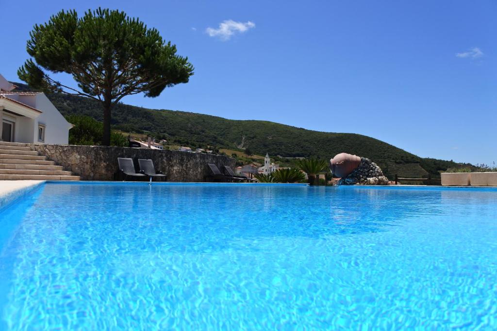 una persona está sentada en una gran piscina en Casa da Eira, en Cadaval