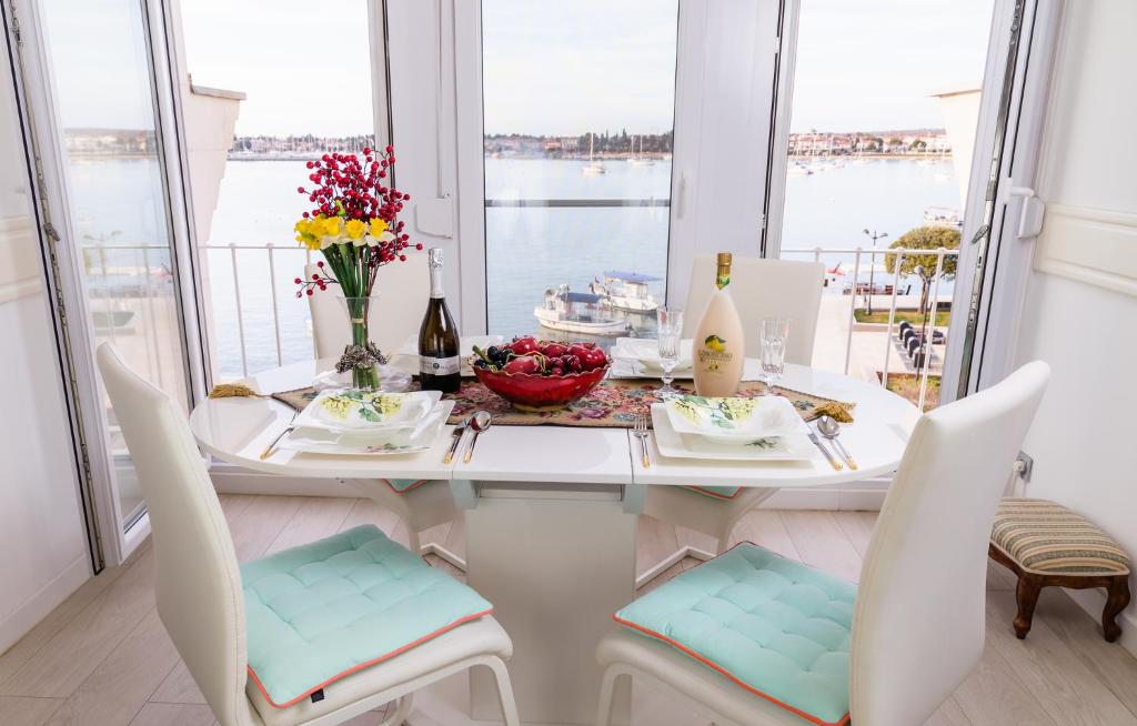 een eetkamer met een tafel en stoelen met uitzicht op het water bij Luxury Apartment Sara in Umag