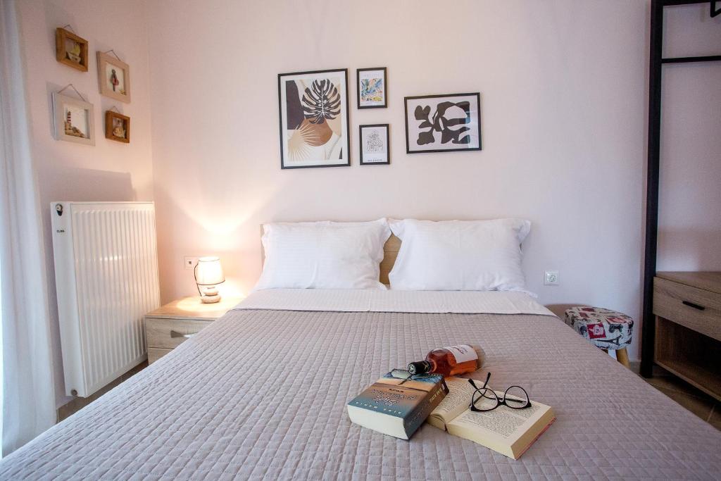 a bedroom with a bed with books and glasses on it at Konstantina & Evgenia Deluxe Apartment in Nea Peramos