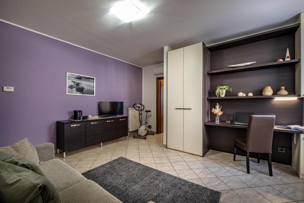 - un salon avec un canapé, un bureau et une table dans l'établissement Arianna Apartment, à Sovicille