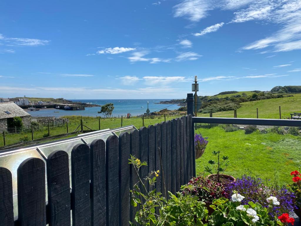 einen Blick auf das Meer von einem Zaun aus in der Unterkunft Islecroft House Bed & Breakfast in Isle of Whithorn