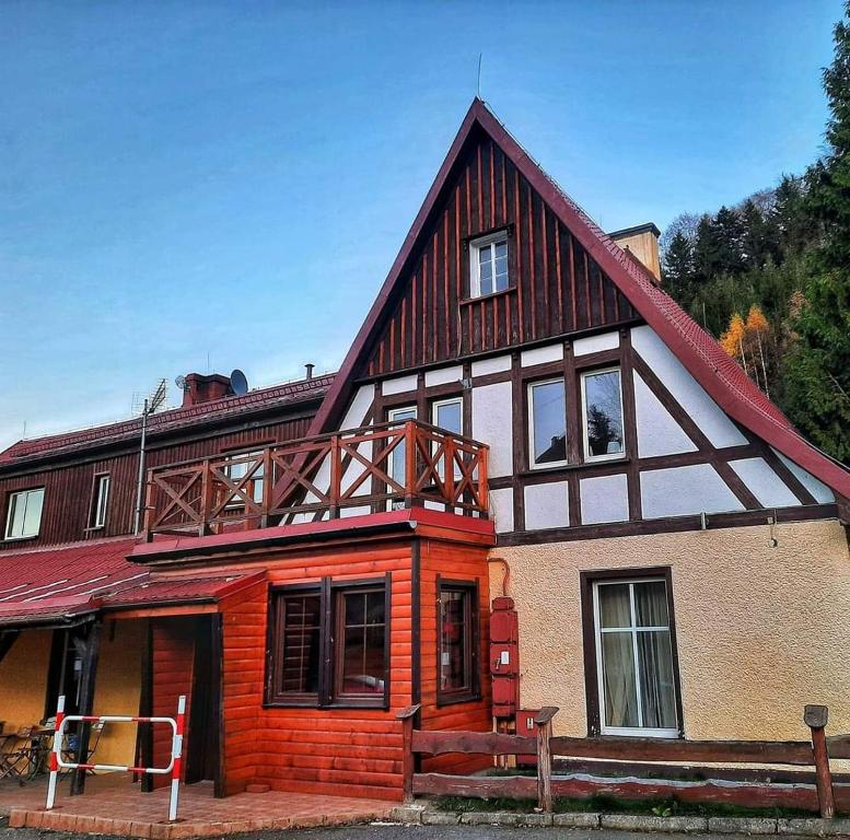 une grande maison en bois avec un toit en gambrel dans l'établissement Przystanek Podgórze, à Duszniki-Zdrój