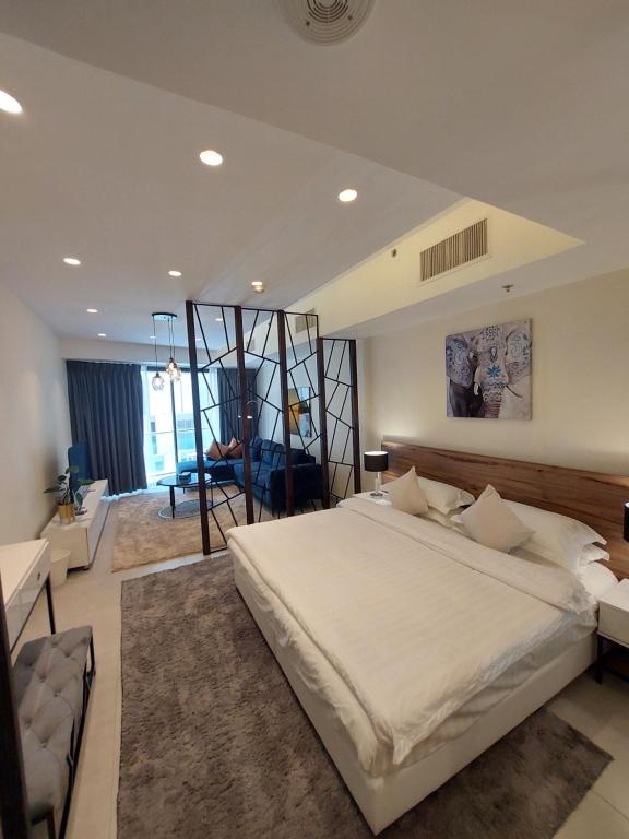 een slaapkamer met een groot wit bed en een woonkamer bij Luxury Studio - Damac Tower Amman in Amman
