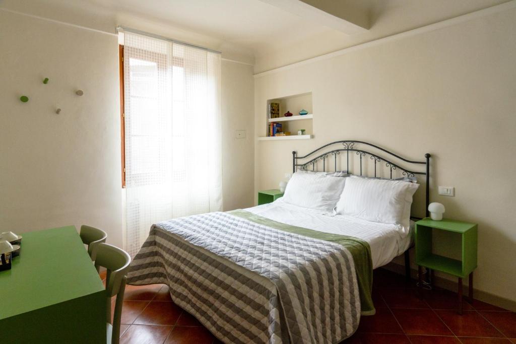 una camera da letto con un letto con una coperta e una finestra di B&B San Francesco a Siena