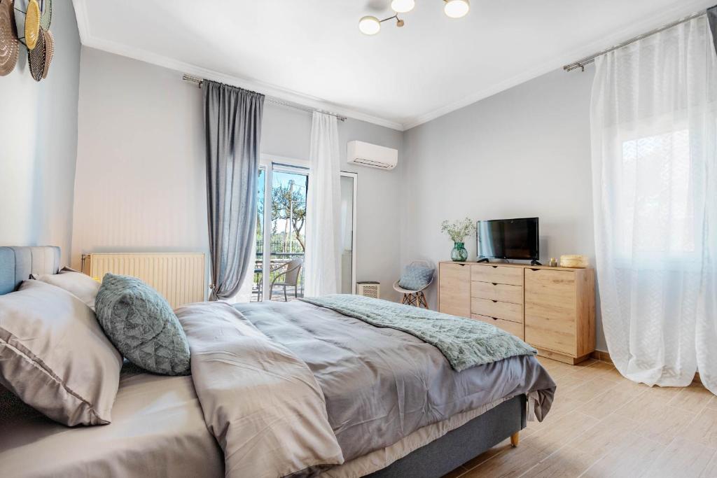 a bedroom with a bed and a dresser and a television at Eftychia's Garden House in Kompítsion