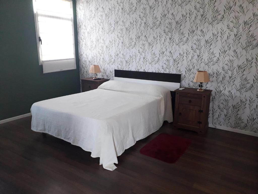 a bedroom with a white bed and two night stands at RELAX III in Paysandú