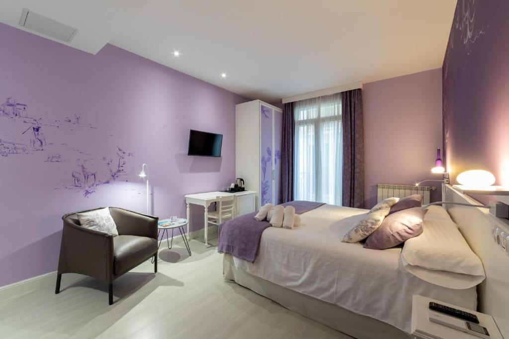 a bedroom with purple walls and a bed and a chair at Ur-Alde in Donostia-San Sebastián