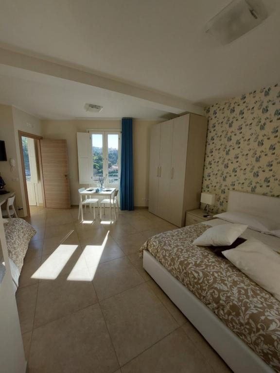 1 dormitorio con 1 cama, mesa y sillas en Oikos - Ragusa Ibla, en Ragusa