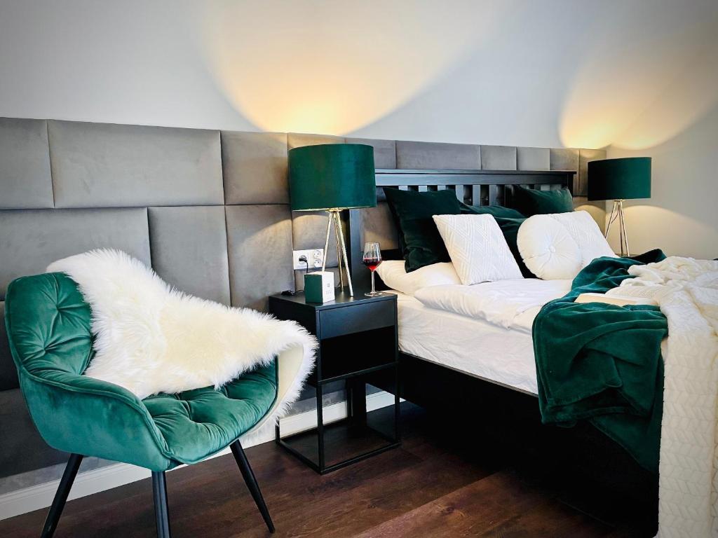 1 dormitorio con 1 cama y 1 silla verde en DeerHome Apartment, en Czarny Dunajec