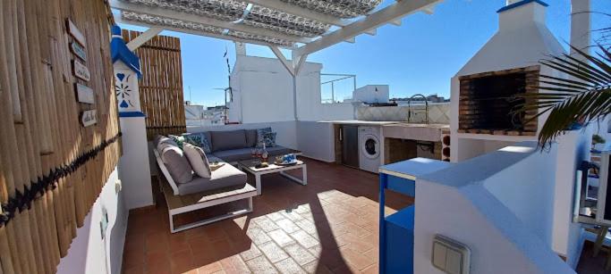 - un balcon avec un canapé et une table dans un bâtiment dans l'établissement Casa Do Pescador, à Olhão