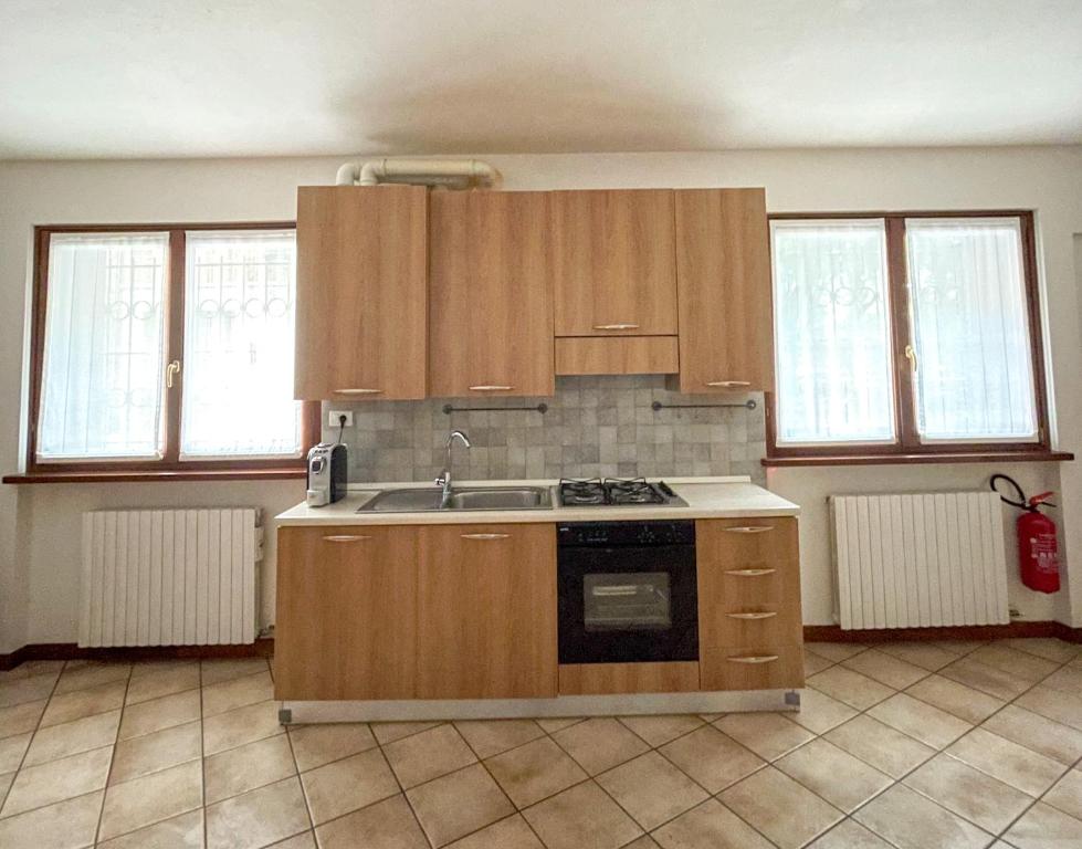 Una cocina con gabinetes de madera y un horno de estufa. en Richi Rent 01, en Verona