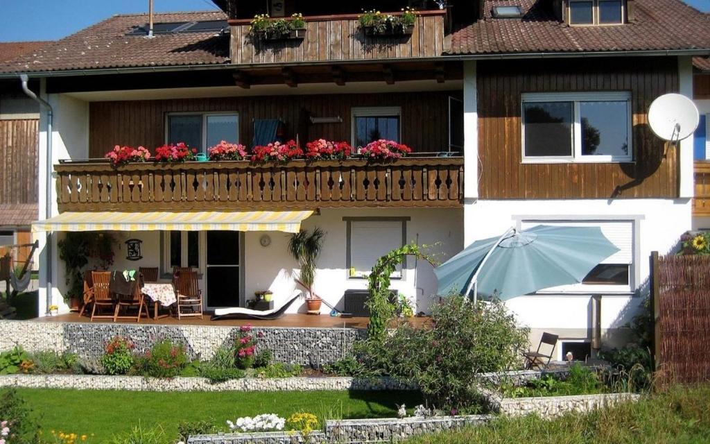 Casa con balcón con sombrilla azul en Ferienwohnung Nr 2, neben Bauernhof, Roßhaupten, Allgäu, en Rosshaupten