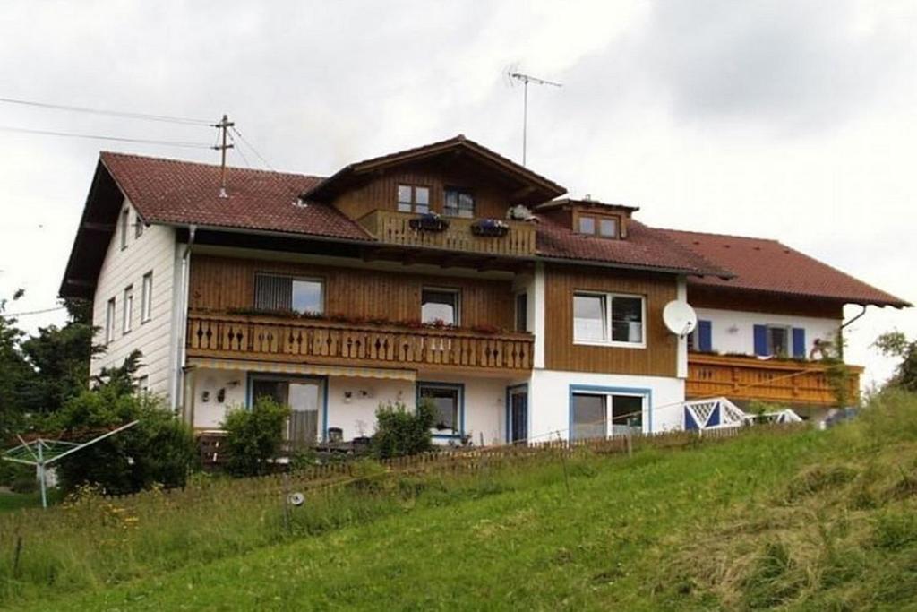 Ferienwohnung Nr 1, neben Bauernhof, Roßhaupten, Allgäu في روسهوبتن: منزل على قمة تلة عشبية