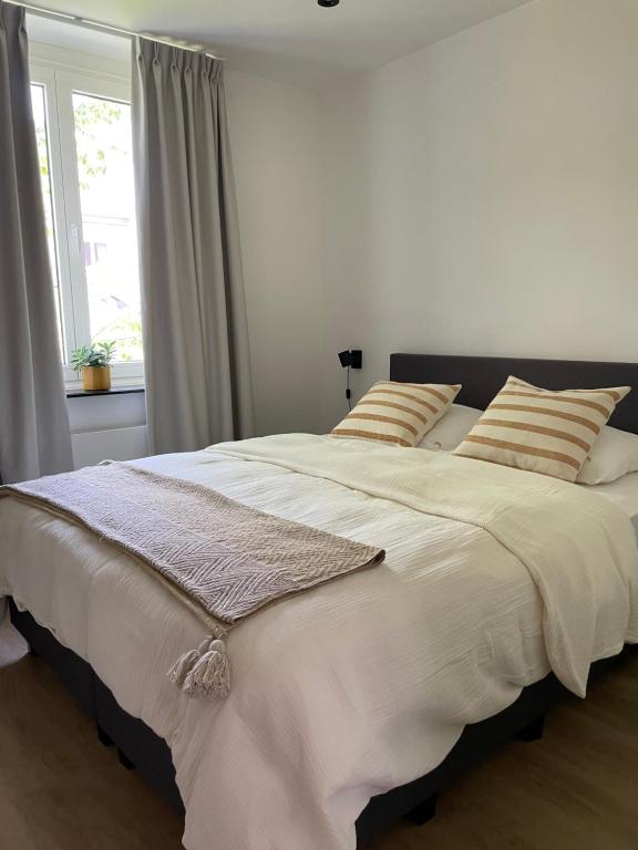 a bedroom with a large white bed with a window at Cabine Congé nieuw appartement dichtbij zee in Ostend