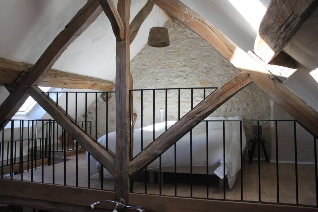 uma vista para um quarto com uma cama no sótão em Cellier de l'abbaye- gîte Tête à Tête em Vézelay