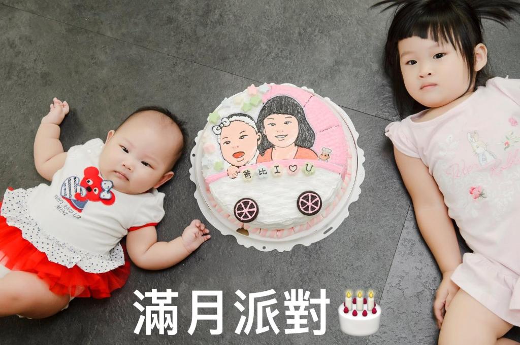a baby and a cake with a picture of two girls at 巴黎Villa C館 in Luodong