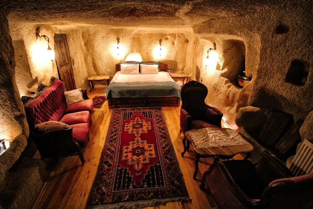 a room with a bed and chairs in a cave at patisca cave house in cappadocia in Urgup