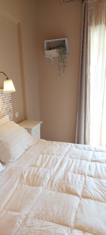 1 cama blanca en un dormitorio con ventana en Cactus Mini, en Nydri