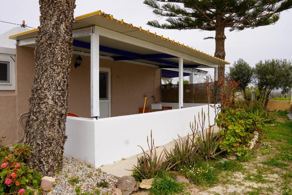 a house with a white fence and a tree at Aelia House in Kos