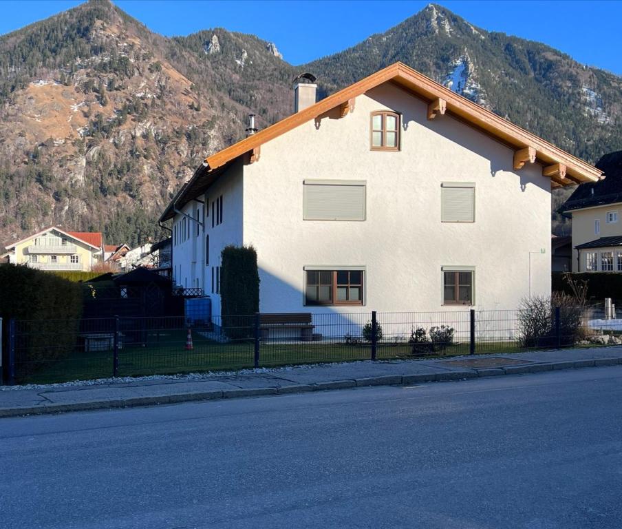 a white house with mountains in the background at Ferienwohnung Wiadahoam in Marquartstein